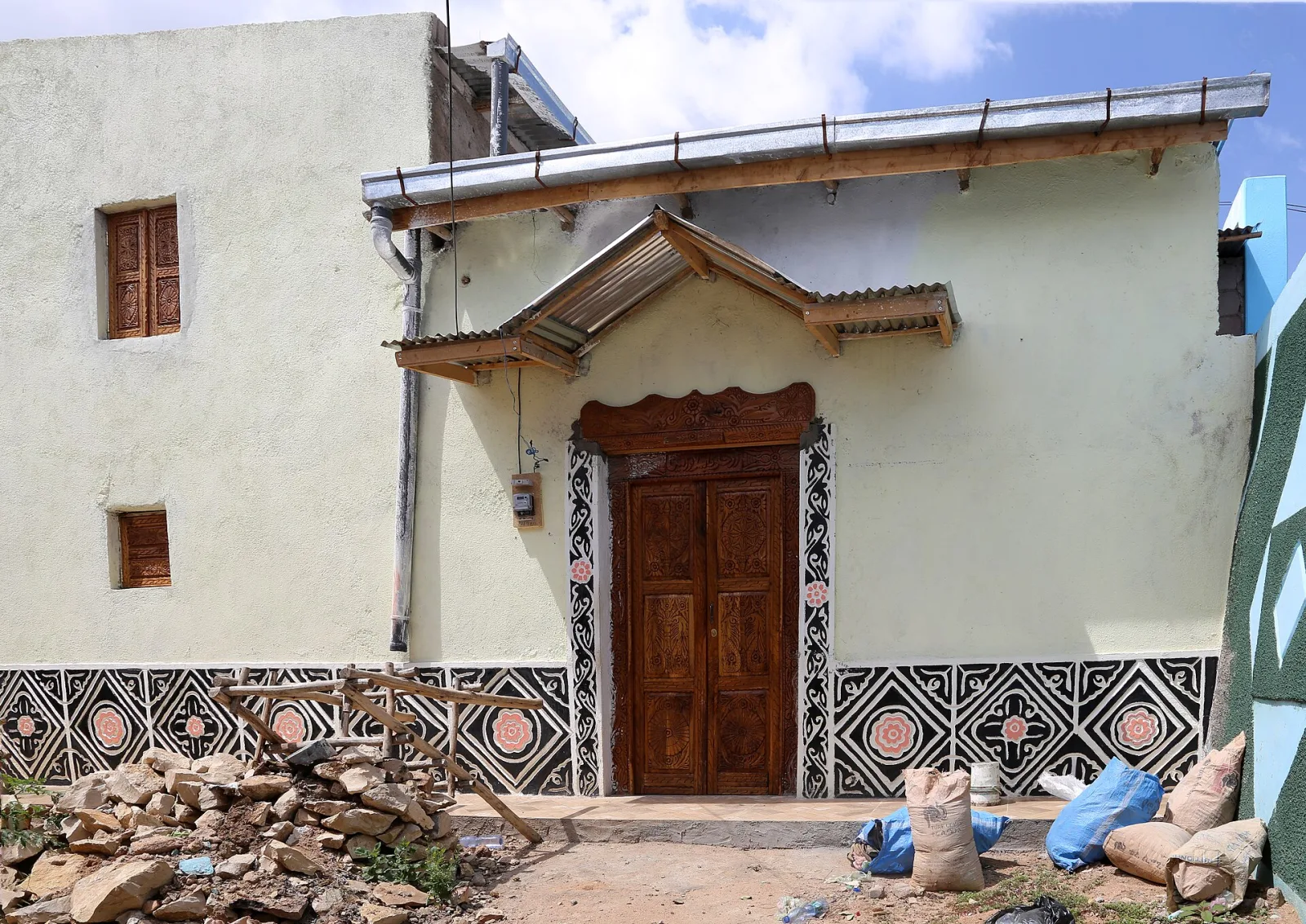 A traditional house in Harar with a carved wooden door and a painted geometric border