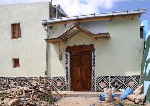 A traditional house in Harar with a carved wooden door and a painted geometric border